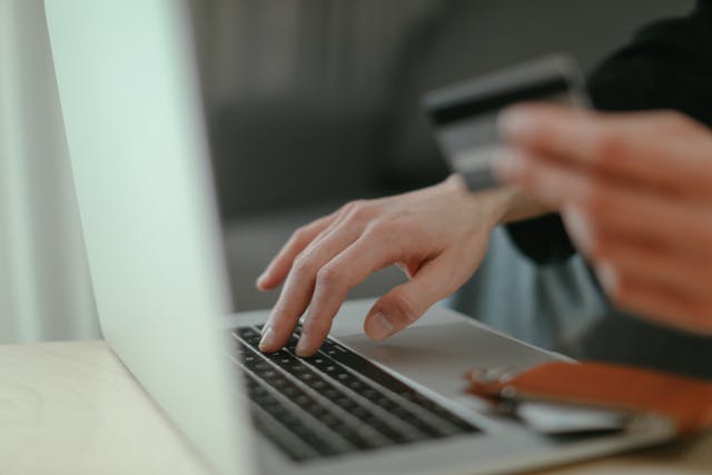 A Person holding a credit card to make an online payment